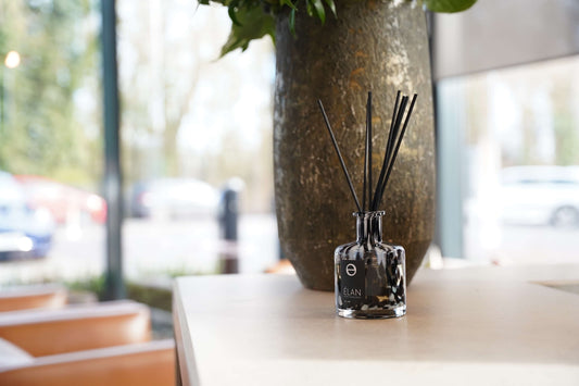 Glass reed diffuser on boardroom table with vase